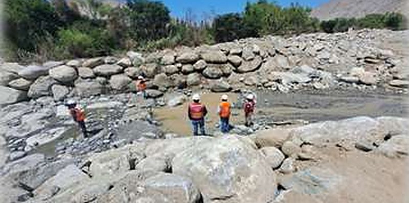 Riprap on a riverbank with workers