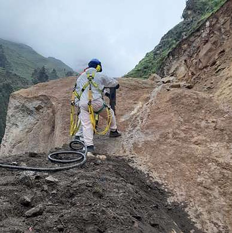 Worker in a safety harness on a rocky slope